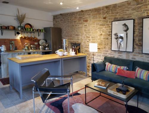 Una sala de estar con un sofá azul y una cocina. en La Parenthèse à Etrigny, en Étrigny