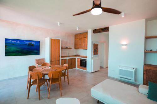 a kitchen and dining room with a table and chairs at Escape by Form Apartament 4 in Dhërmi