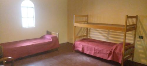 una camera da letto con due letti a castello e una finestra di Willca Pirul a San Marcos Sierra