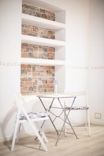 a white desk and a chair in front of a brick wall at Residenza Portoferraio in Portoferraio