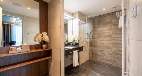 a bathroom with a sink and a shower at PLAZA Premium Heidelberg in Heidelberg