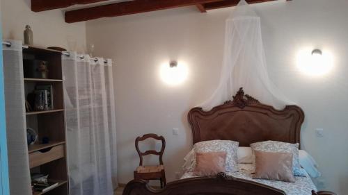 - une chambre avec un lit à baldaquin en bois dans l'établissement Chez Eugène et Valérie, à Saint-Cybardeaux