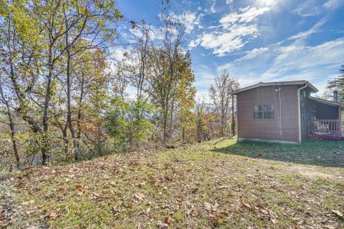 a small house in the middle of a yard at Cabin with Deck and Mountain Views Near Gatlinburg! in Cosby