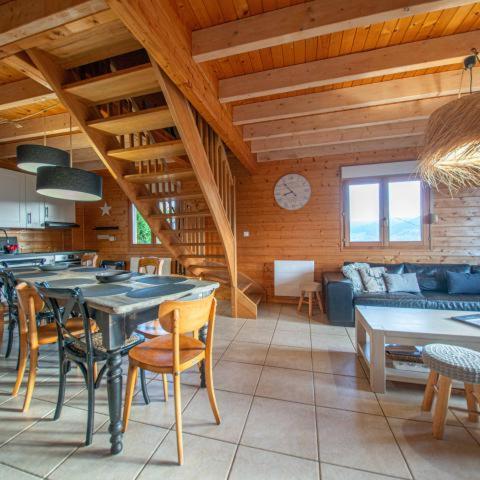 - une cuisine avec des tables et des chaises dans une pièce dans l'établissement Chalet Lipa - Confort et Sauna au cœur des Vosges, à La Bresse