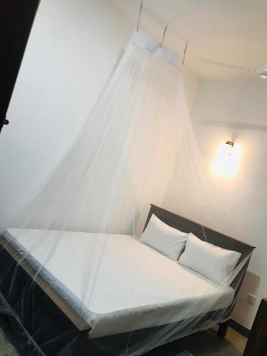 a bed with a net in a room at Emerald Coast Hotel Negombo in Daluwekotuwa