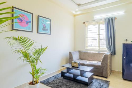 a living room with a couch and a table at Housr Charlie, HSR Layout Bengaluru in Bengaluru