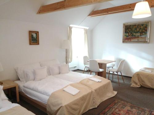 a bedroom with a bed and a table and chairs at Penzion Nad Kašnou in Kašperské Hory