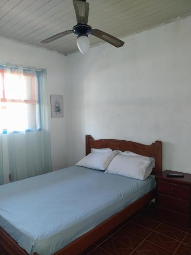 a bedroom with a bed with a ceiling fan at Casa nossa hospedagem centro in Paraty