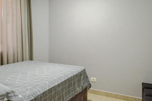 a bedroom with a bed and a white wall at Casa ENORME, segurança e conforto para sua família in Cascavel