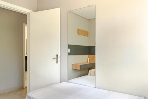 a bedroom with a door leading to a bathroom at Casa ENORME, segurança e conforto para sua família in Cascavel