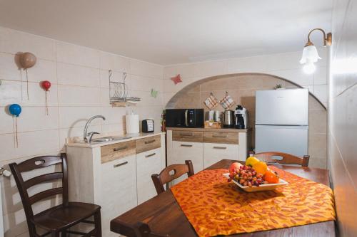a kitchen with a table with a bowl of fruit on it at La Casetta Antica in Noci