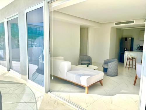 a living room with a white couch and chairs at Park Life Nautico in Nuevo Vallarta