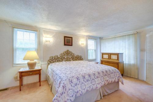 a bedroom with a bed and a lamp and windows at Spacious Studio - 5 Mi to MGM Northfield Park! in Maple Heights