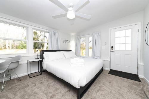 a white bedroom with a bed and a ceiling fan at Admiral's Retreat - iTrip Annapolis in Annapolis