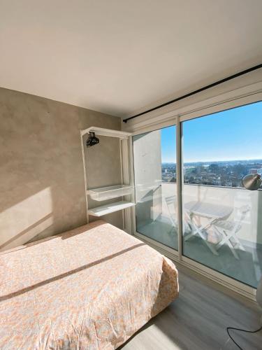 une chambre avec un lit et une grande fenêtre dans l'établissement Chambre PRIVÉE dans appartement PARTAGÉ - Le Voltaire - Talence - WIFI - REF F1, à Talence