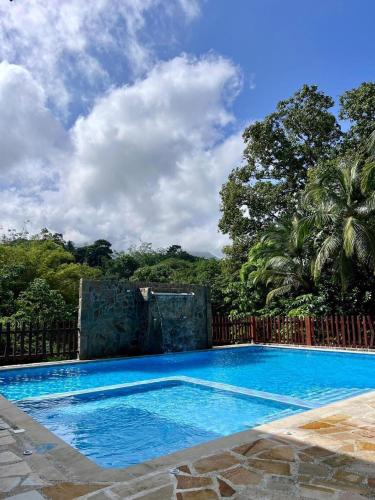 a large blue swimming pool next to a fence at Arca Tayrona Restaurant & Hostal in Santa Marta
