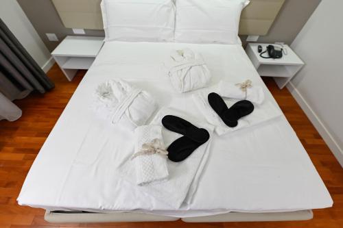 a white bed with shoes and towels on it at Hotel Hypnos in San Giorgio Montagna