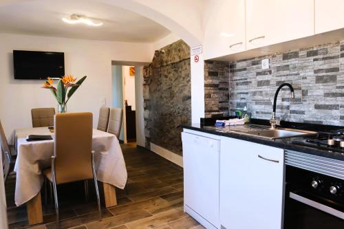 a kitchen and dining room with a table and a sink at Casa Tio Albino I, By OP in Ponta Delgada