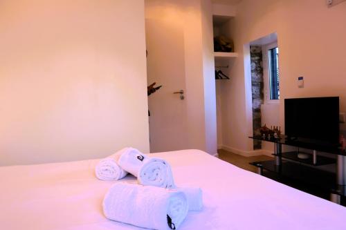 a bedroom with towels on a bed with a television at Casa Tio Albino I, By OP in Ponta Delgada