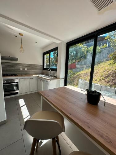 a kitchen with a wooden table and a large window at Forecastle House in Saint-Louis