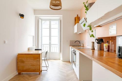 - une cuisine avec des murs blancs et un comptoir en bois dans l'établissement Appartement cosy hypercentre T3 Graslin, à Nantes