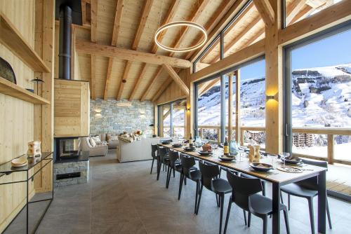 une salle à manger avec une longue table et des chaises dans l'établissement Odalys Chalet L'Ours Brun, à Les Deux Alpes