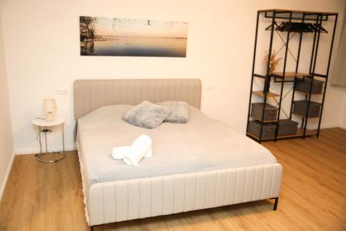 a white bed in a room with a shelf at Ferienwohnung Studio LANA in Bad Zwischenahn