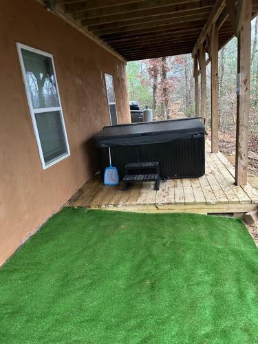 a screened in porch with a large grill and green grass at windrock ridge - Ethan in Oak Ridge