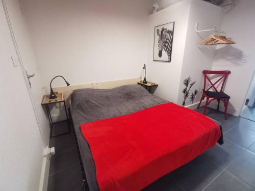- une chambre avec un lit rouge et une couverture rouge dans l'établissement Neptuna, au Cap d'Agde