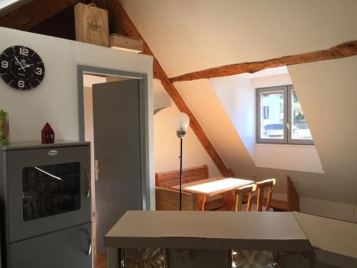 une cuisine avec une table et une horloge au mur dans l'établissement Apartement montagne dans maison de caractères, à Esterre