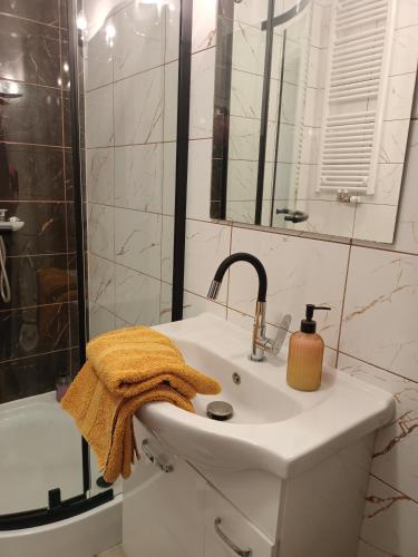 a white bathroom with a sink and a shower at Apartament 41 in Rumia