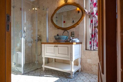 ein Badezimmer mit Waschbecken und Dusche mit Spiegel in der Unterkunft Fener burnunda Denize sıfır orjinaltaş malikane in Cesme