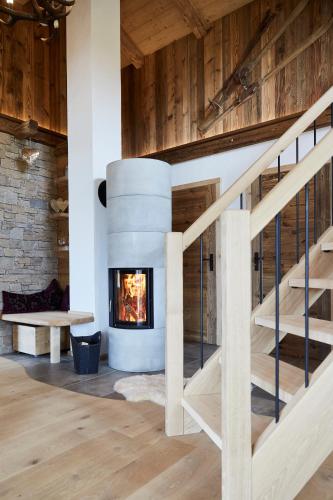 a fireplace in a living room with a staircase at Dreisessel-Chalets im bayerischen Wald - Chalet Plöckenstein - mit Whirlpool-Sauna-Kamin in Haidmühle