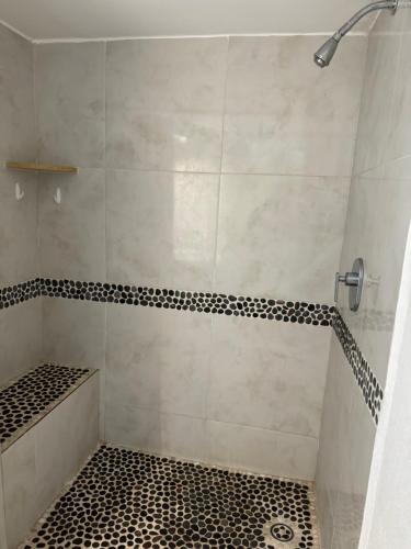 eine Dusche mit schwarz-weiß gefliestem Boden in der Unterkunft Ixtapa zihuatanejo, Departamento vacacional- in Zihuatanejo