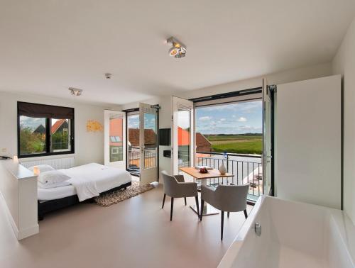 a bedroom with a bed and a balcony at Relaîs & Châteaux Bij Jef in Den Hoorn