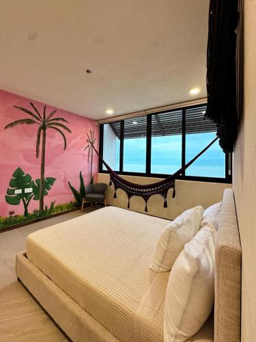 a bedroom with a large bed with a palm tree mural at Breathtaking Ocean Vista Penthouse with Private Pool in Holbox Island