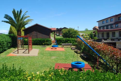 a playground with playground equipment in a yard at Hotel Piedra in Perlora