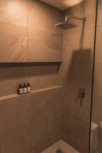 a bathroom with a shower with a glass door at Breathtaking Ocean Vista Penthouse with Private Pool in Holbox Island