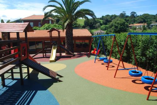 a playground with swings and a slide at Hotel Piedra in Perlora
