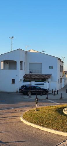 a building with a car parked in a parking lot at Villa vue sur la mer in Saintes-Maries-de-la-Mer