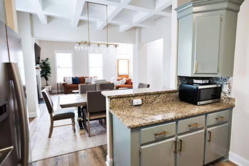 a kitchen and living room with a table with a microwave at Pink House with Game Room - 3BR in Columbia
