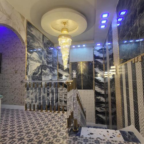 a large room with a chandelier and a tile floor at Luxury 6 bedrooms villa with private swimming pool in Ajman