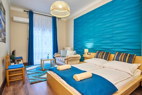 1 dormitorio con 1 cama grande y pared azul en Vilmos-Lak, en Budapest