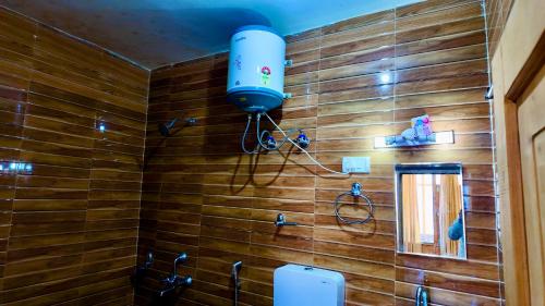 a bathroom with a blue light on a wooden wall at Apple hills Resort in Jibhi