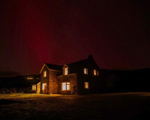 a stone house at night with the lights on at Coorlacka in Ballydivin