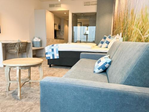 a living room with a couch and a bed at SlowDown Bottsand Hotel und Spa in Wendtorf