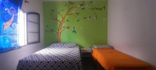 a room with a bedroom with a tree and a bed at Casa da praia, Caraguatatuba in Caraguatatuba