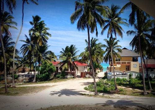 a group of palm trees and houses on a beach at Kite Active Paje in Paje