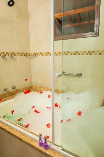 a shower with red flower petals on the floor at Pousada Campos de Provence Campos do Jordão in Campos do Jordão