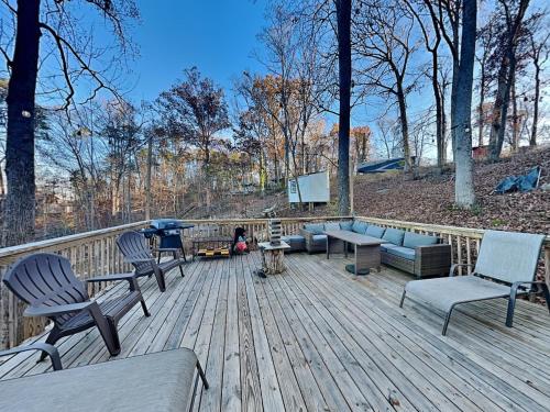a deck with chairs and a couch and a television at Emerald Cove in Dandridge